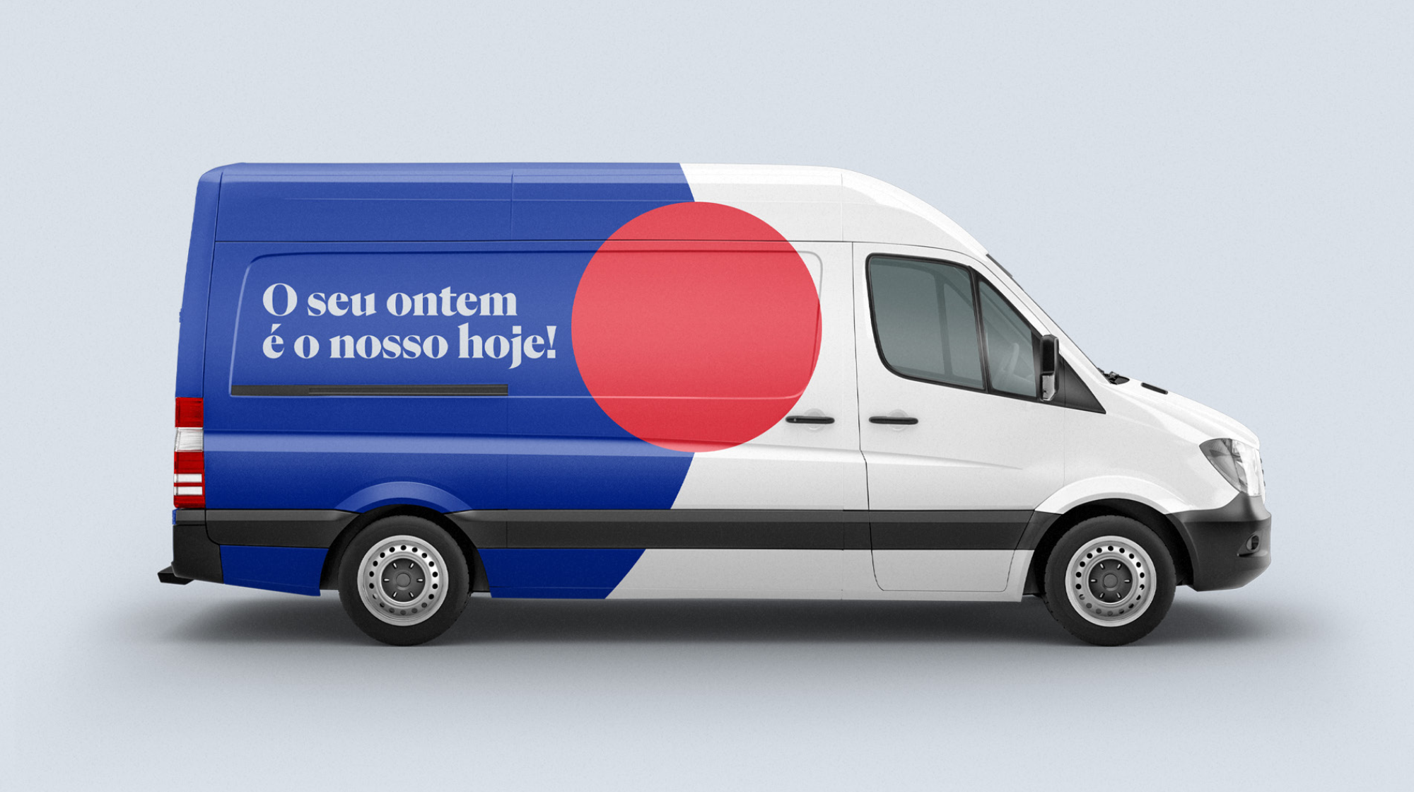 Lateral da van com o círculo vermelho e a frase O seu ontem é o nosso hoje